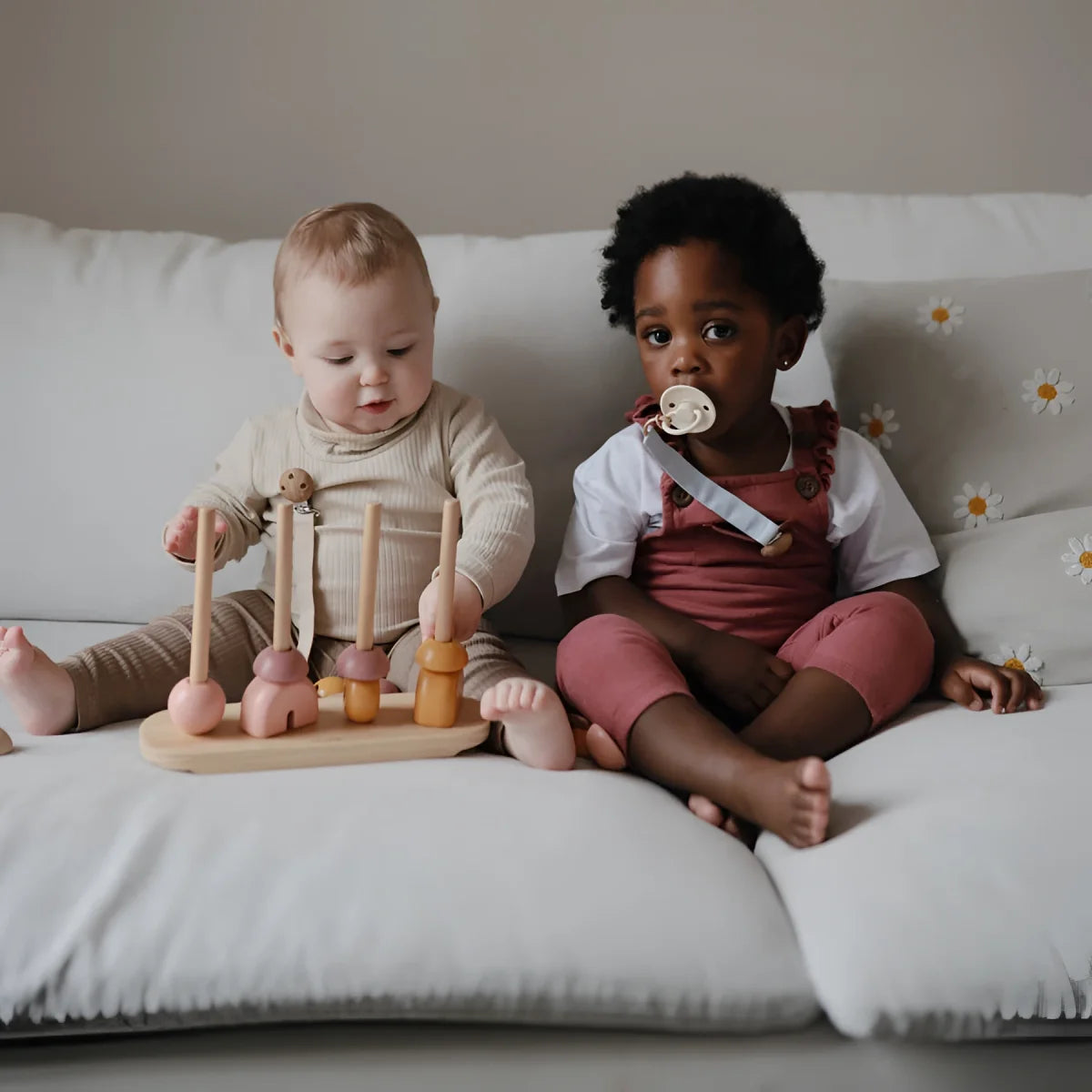Zwei Babys sitzen zusammen auf einer weißen Couch mit Schnuller Silikon 4-Pack