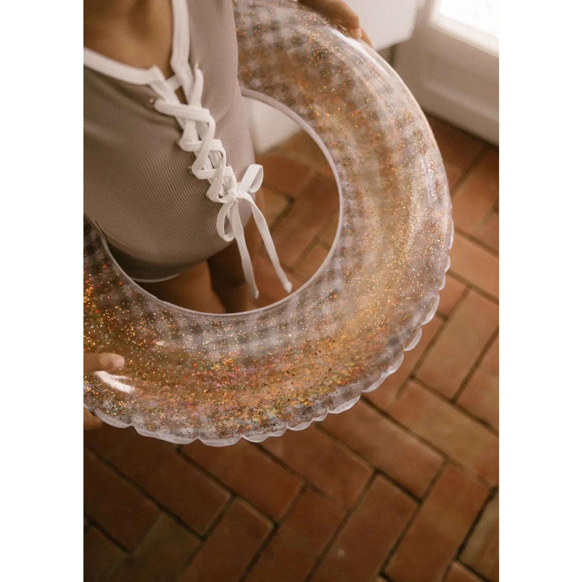 Klarer schwimmring love confetti mit gold- und mehrfarbigen glitzerwirbeln und gewelltem rand nachhaltige babykleidung