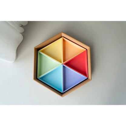 Sechseckige Mandigo Spielschale aus Holz mit sechs pastellfarbenen Dreieck-Einsätzen in Gelb, Orange, Grün, Rot, Blau