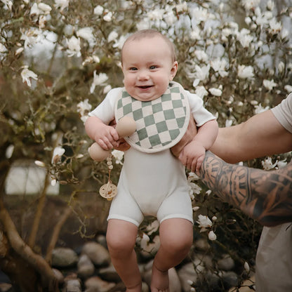 Baby Onesie mit Karo-Schürze, weiß-grün, Baumwolle, Silikon Rassel Sand