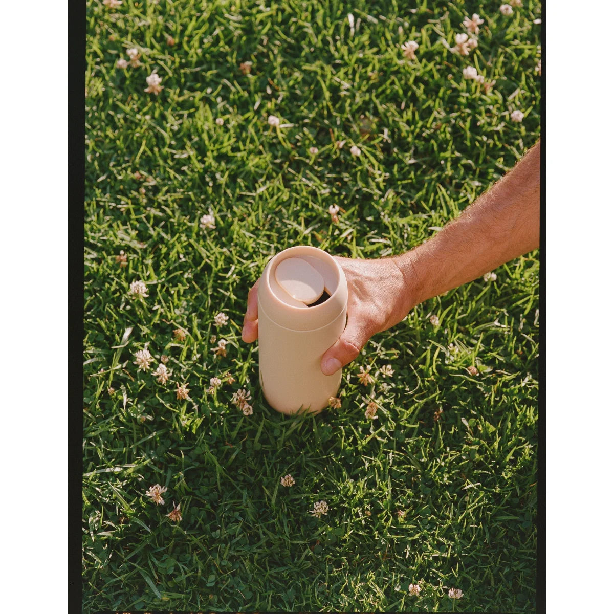 Hand hält einen beigen wiederverwendbaren Trinkbecher Sip Tumbler Thermal Mug Sand