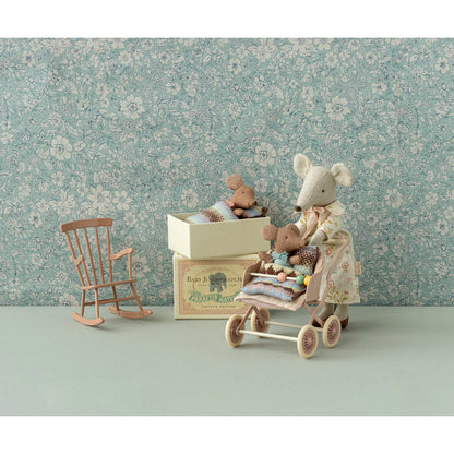 Spielzeugmaus schiebt Kinderwagen mit kleinen Spielzeugen im Rose-Streichholzschachtel