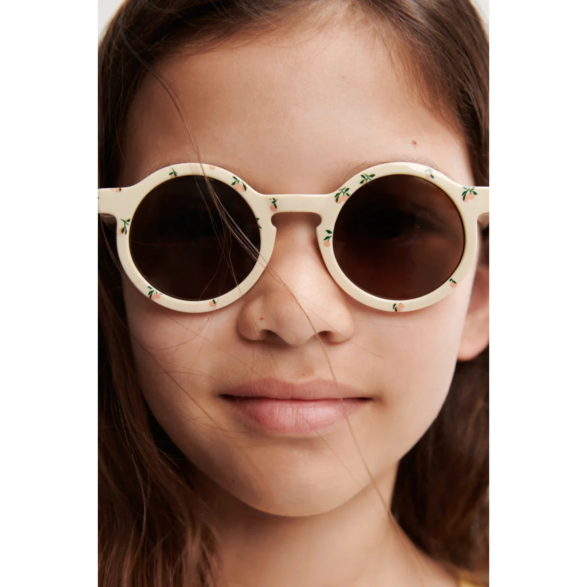 Darla Sonnenbrille für Kinder: Cremefarbene runde Brille mit Blüten-Dekor aus recyceltem Polycarbonat