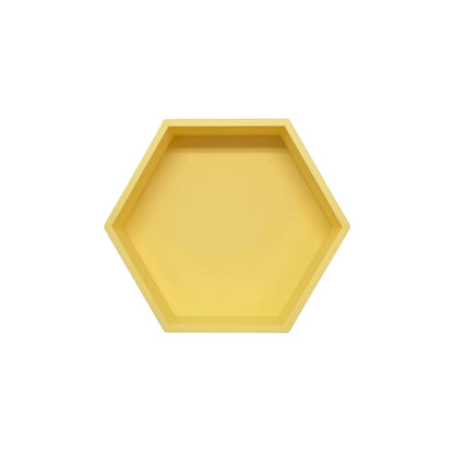 Ein mattgelbes sechseckiges spielschälchen mandigo mit klaren linien und flacher tiefe aus robustem material