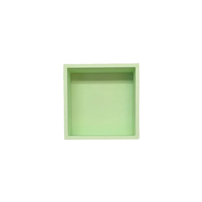 Ein minimalistisches quadratisches spielschälchen mandigo in sanftem mintgrün aus glattem, mattiertem material