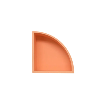 Ein matt lackiertes korallenorange spielschälchen mandigo in viertelkreisform mit minimalistischer ablagefläche