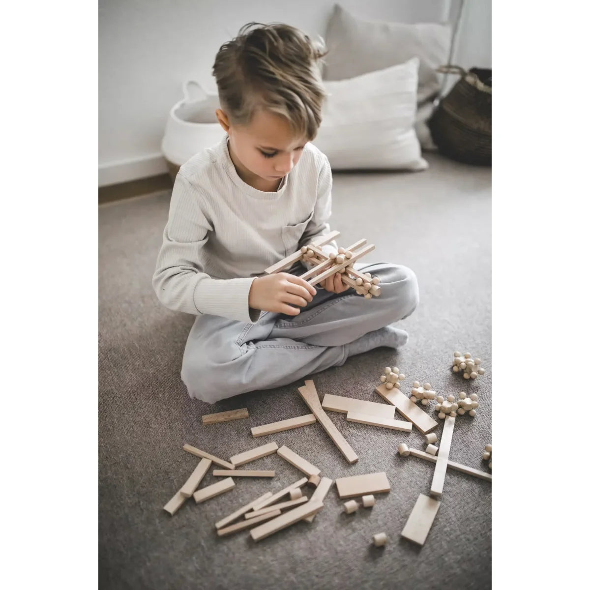 Kind trägt START 140 Spielset zusammen: Brixis, Twister, Timber Bricks