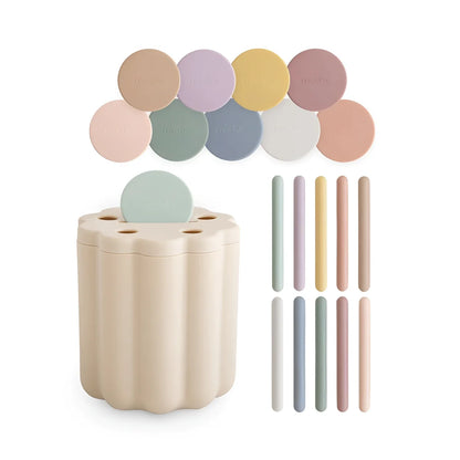 Beige geripptes Silikon-Steckspiel für Münzen mit passendem pastellfarbenem Deckel und bunten zylindrischen Steckteilen