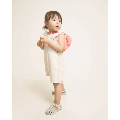 Kleines Kind in nachhaltiger Babykleidung Schweiz: weißes Trägerkleid mit Erdbeer-Details