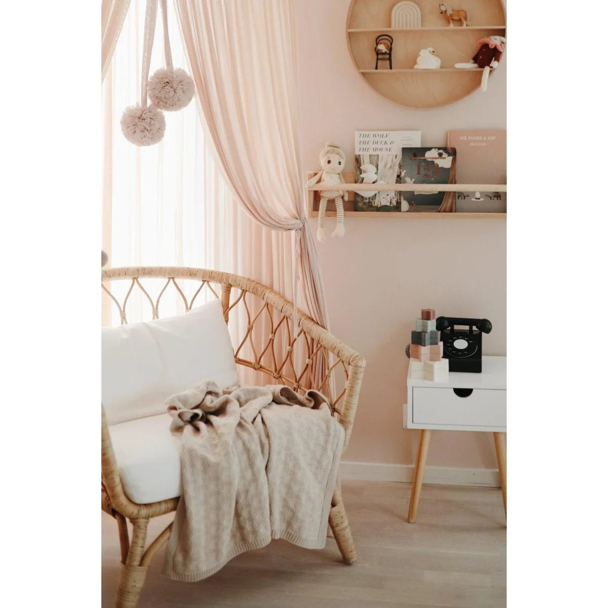 Rattan baby crib with soft bedding and canopy, paired with Strickdecke Honeycomb Beige