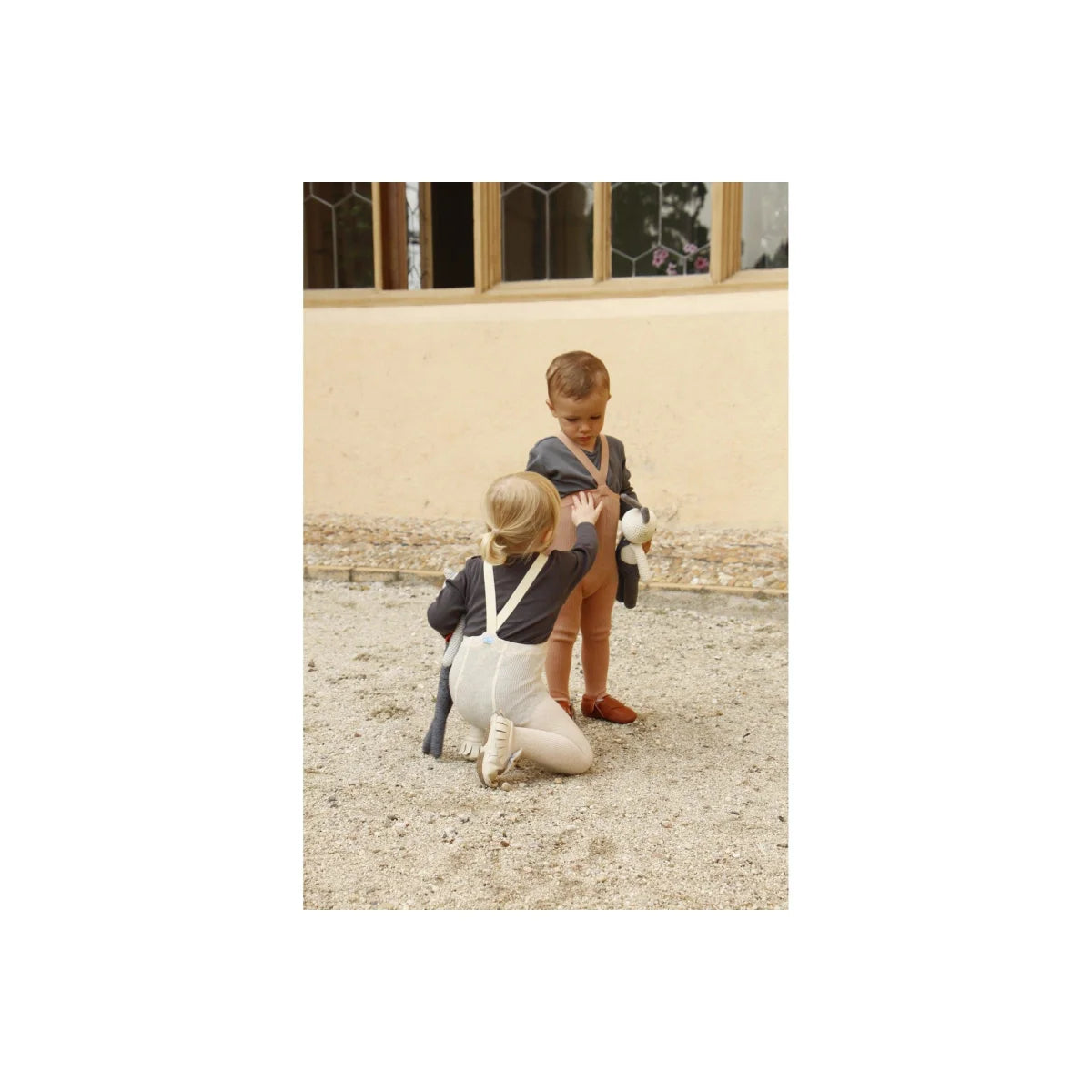 Zwei Kinder in Matrosen-Outfits spielen draußen mit Strumpfhose mit Träger
