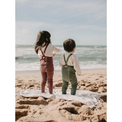 Zwei Kinder am Strand, die dem Ozean entgegen sehen, mit Strumpfhose Acai Smoothie