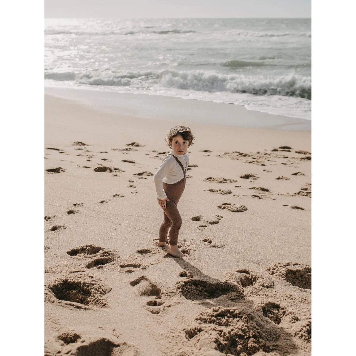 Junger Mensch in Vintage-Kleidung am Strand mit Strumpfhose mit Träger Footless