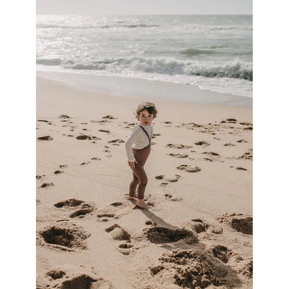 Junger Mensch in Vintage-Kleidung am Strand mit Strumpfhose mit Träger Footless