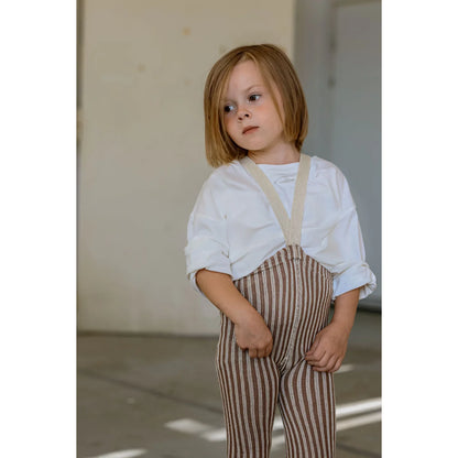 Kind mit weißem Hemd und Granola-Creme-Streifen-Overalls mit Trägern