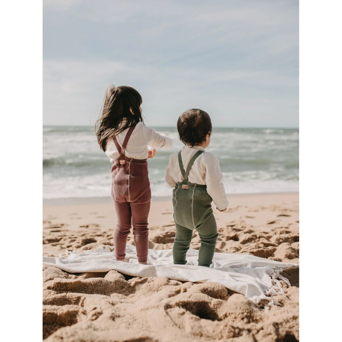 Zwei Kinder am Strand, blickend auf den Ozean mit Strumpfhose Matcha Oat Latte
