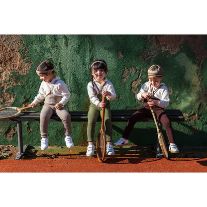 Drei Kinder mit Tennisschlägern neben Strumpfhose mit Träger Footless in Olive gestreift