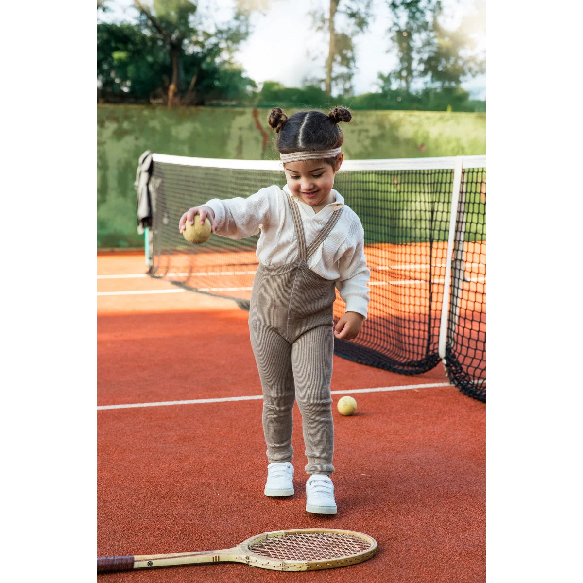 Kind spielt Tennis in Strumpfhose mit Träger Footless in Oysterschwarz gestreift
