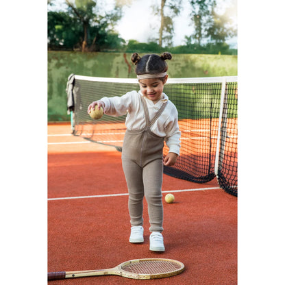 Kind spielt Tennis in Strumpfhose mit Träger Footless in Oysterschwarz gestreift