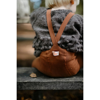 Kind trägt grauen Pullover und braune Corduroy-Latzhosen für Strumpfhose mit Träger
