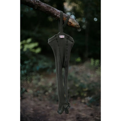 Dunkelgrüner Jumpsuit hängt an einem Baumast, präsentiert für Strumpfhose mit Träger Footed