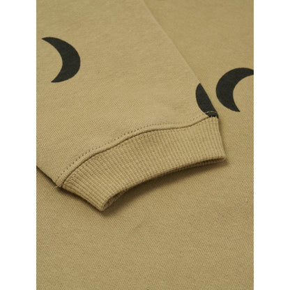 Nahaufnahme eines beigen Sweatshirtärmels mit schwarzen Halbmondmustern und Rippenbündchen
