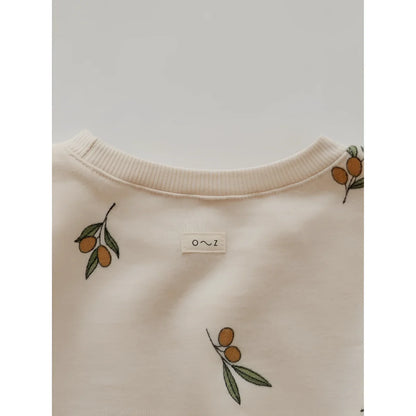 Cremefarbener Pullover mit einem Muster aus Olivenzweigen und Früchten