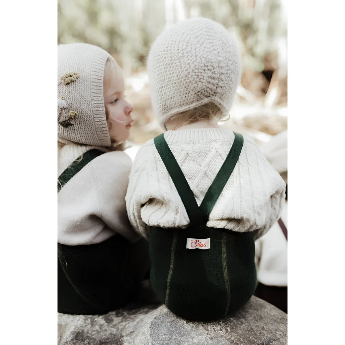 Zwei Kinder in Winterkleidung mit Teddy Warmy Strumpfhosen in Dunkelgrün