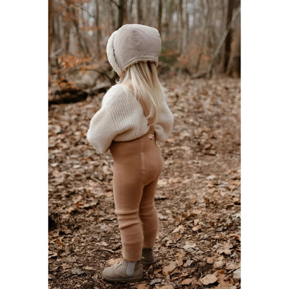 Kind im Wald mit beigem Hut, cremefarbener Jacke und braunen Hosen in Teddy Warmy Strumpfhosen