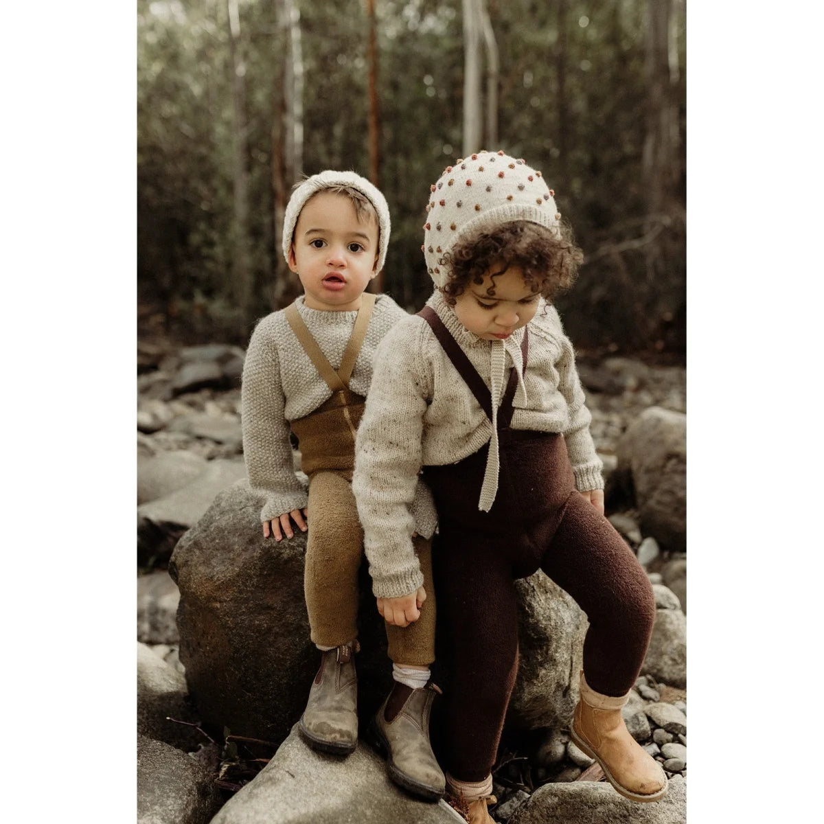 Zwei Kinder in Vintage-Kleidung sitzen auf einem Felsen und tragen Teddy Warmy Strumpfhosen