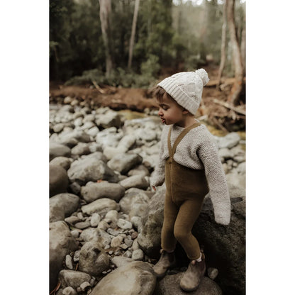 Kind trägt eine Strumpfhose mit Trägern auf steinigem Gelände in Acorn Brown