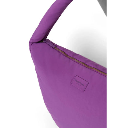 Texturierte pufferähnliche crossbody-tasche in lila mit goldfarbenem reißverschluss und kleinem rechteckigem markenlabel