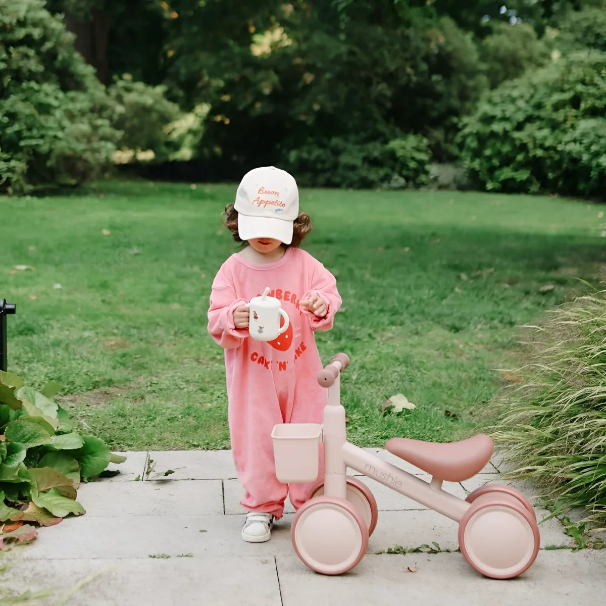 Rosa kinderdreirad mit korb und weichem sitz neben training cup mit silikonstrohhalm fairy mice