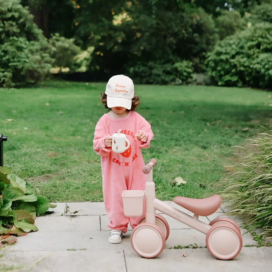 Rosa kinderdreirad mit korb und weichem sitz neben training cup mit silikonstrohhalm fairy mice