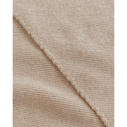 Nahaufnahme von hellbeigem, fein gestricktem Stoff beim Triangle Schal Josephina Sand
