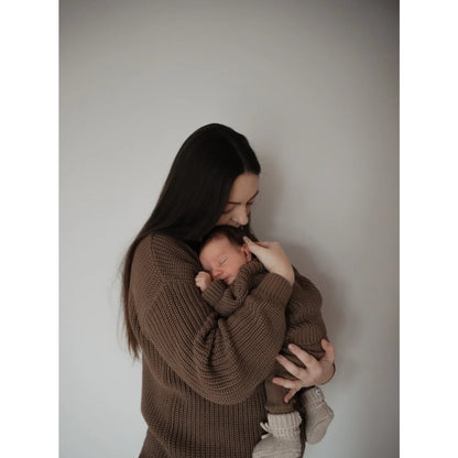 Mutter hält neugeborenes Baby in braunen Strickoutfits, passend zum Women Chunky Knit Sweater