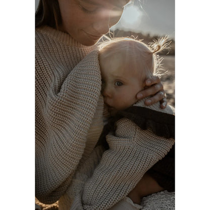 Mutter umarmt Baby in einem gemütlichen Women Chunky Knit Sweater in Oat