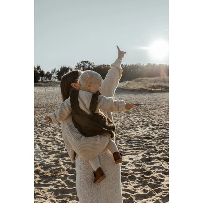 Person mit Kind auf dem Rücken am Strand in einem Damen Chunky Knit Sweater in Oat