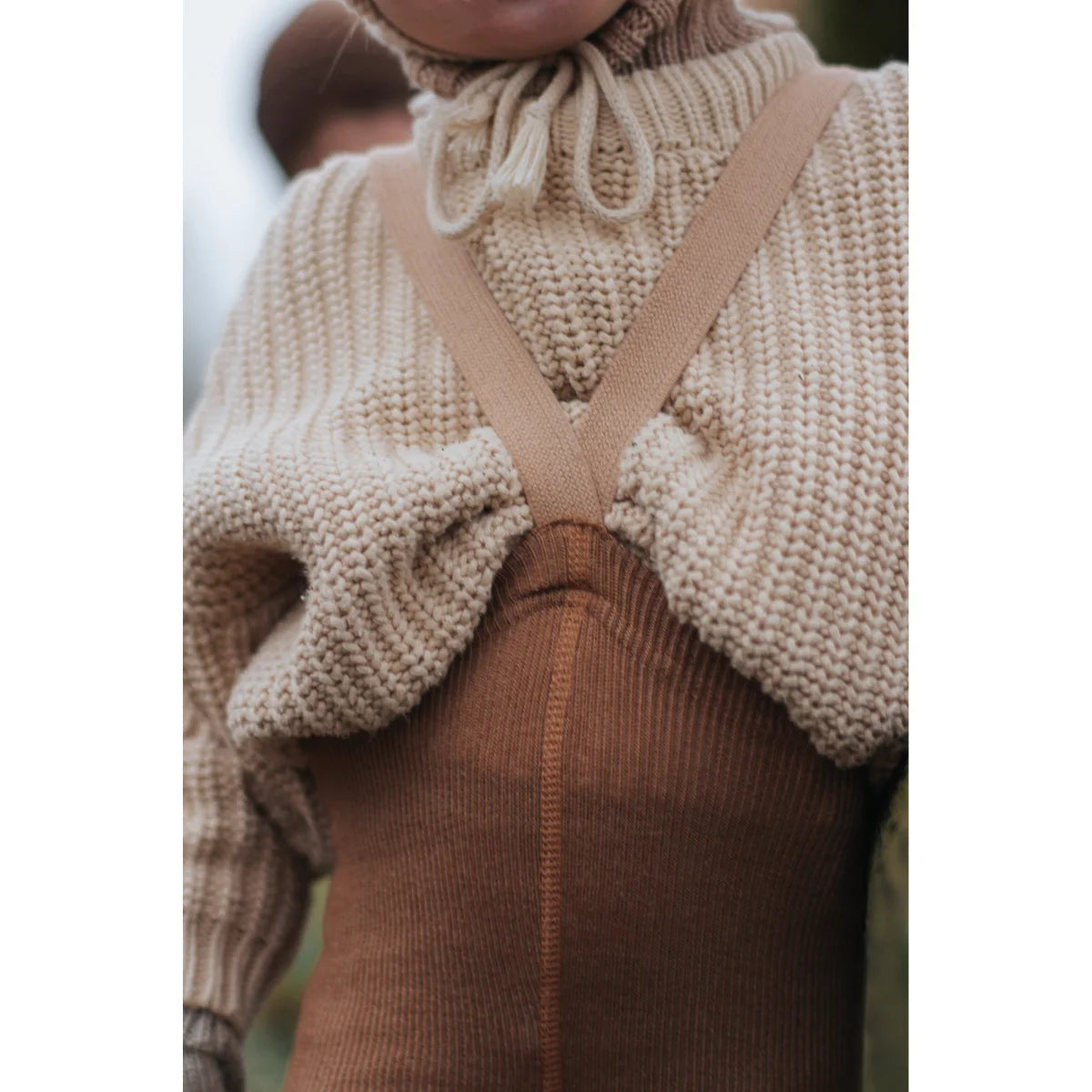 Cremefarbenes Strickshrug über braunem Top mit hohem Kragen in Cappuccino Braun