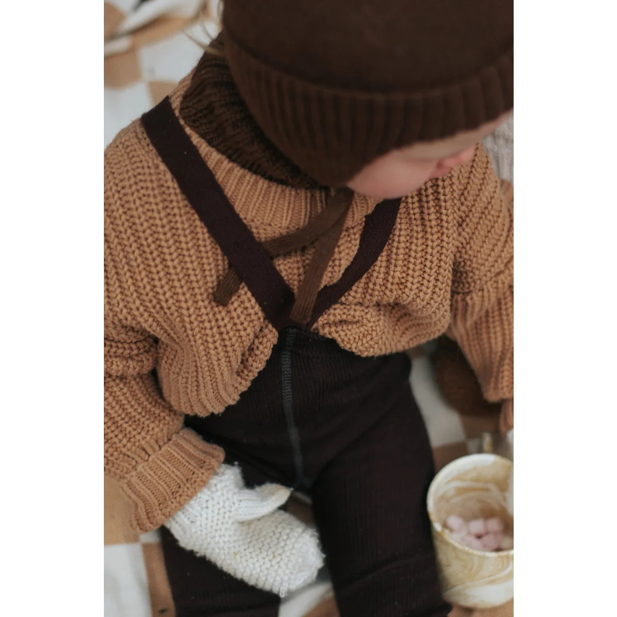Chunky karamelfarbener Pullover über dunklen Latzhosen mit Wooly Strumpfhosen
