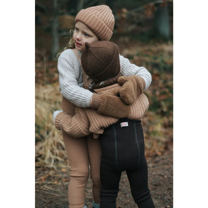 Zwei Kinder umarmen sich im Freien, während sie Wooly Strumpfhosen tragen