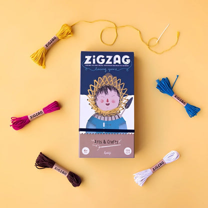 Zig Zag Spielbox mit bunter Stickgarn und Nadel drumherum